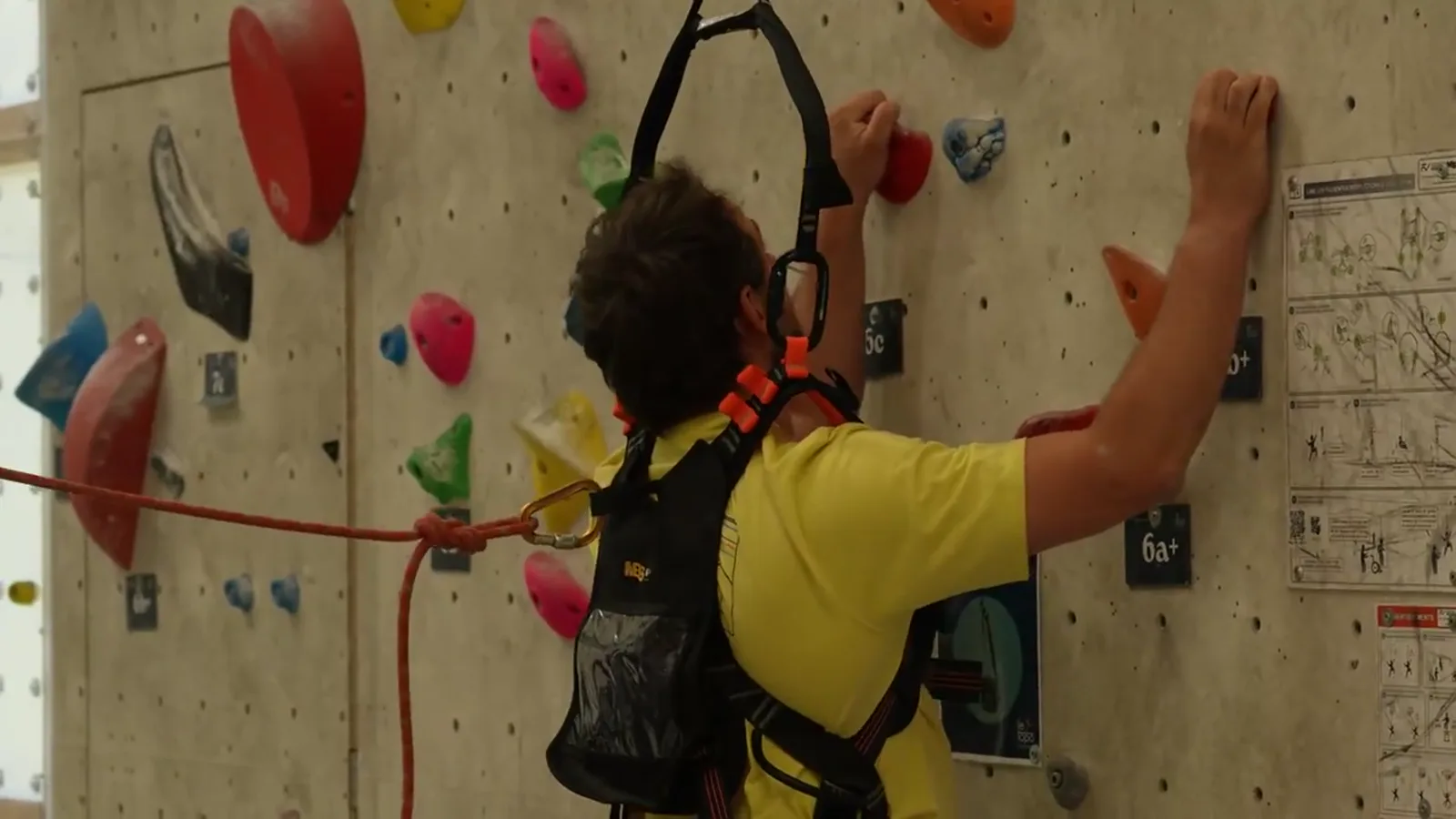 Un grimpeur accompagné sur un mur d’escalade, extrait du film Accès Mont Blanc