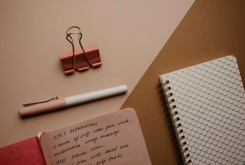 Carnet, stylo et accessoires sur une table de préparation.