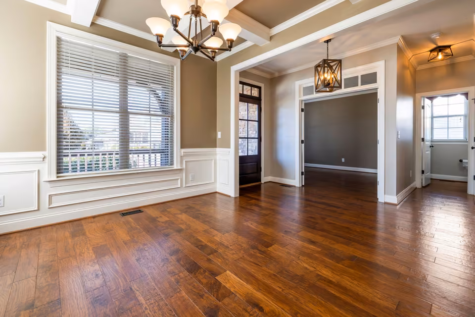 Pièce vide avec parquet sombre et plafond décoratif