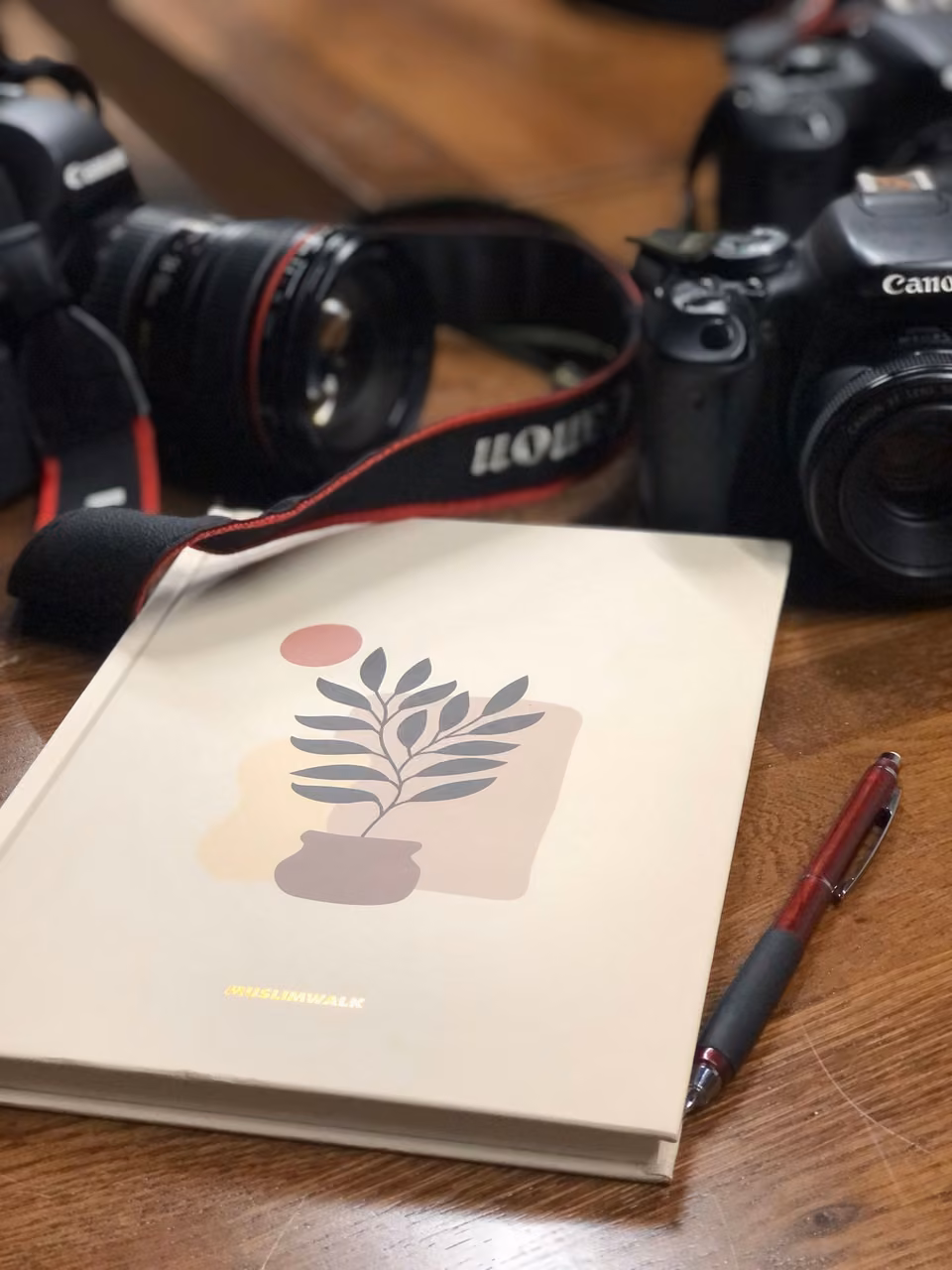 Appareils photo et carnet sur une table en bois