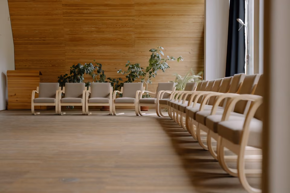 Sièges en bois dans une salle de réception moderne et calme.