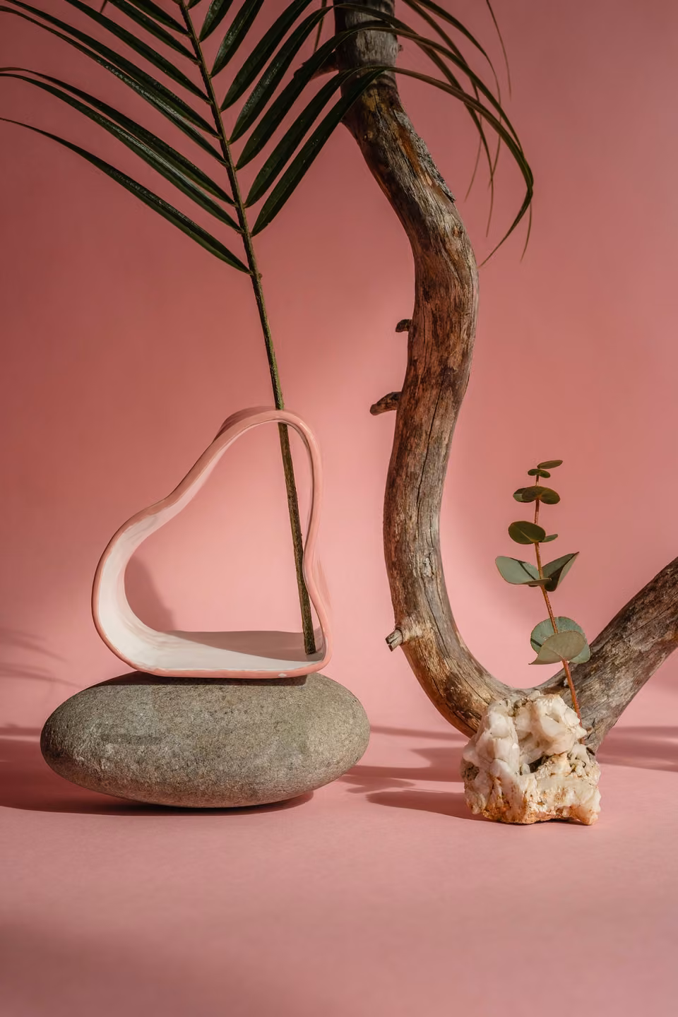 Vase sculptural en céramique sur une pierre et fond rose