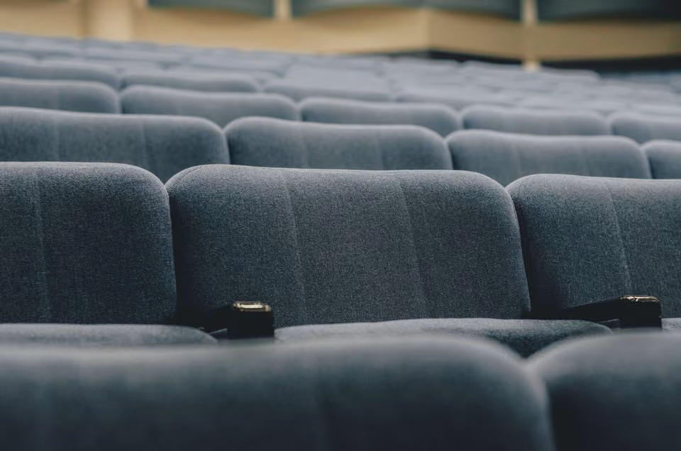 Rangées de fauteuils vides dans un auditorium.