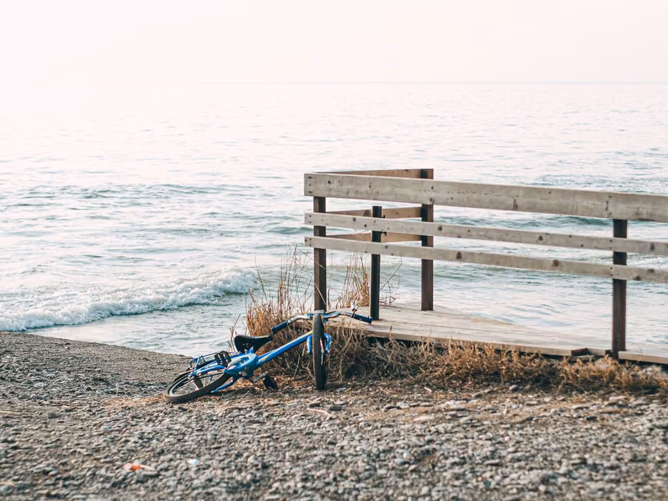 Vélo posé près d’un banc face à la mer.