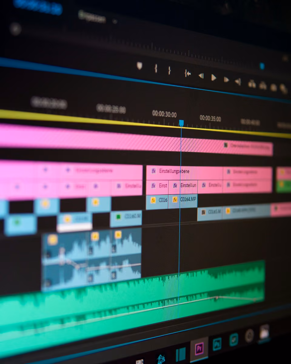 Gros plan vertical d’une timeline vidéo colorée et de formes d’onde audio.