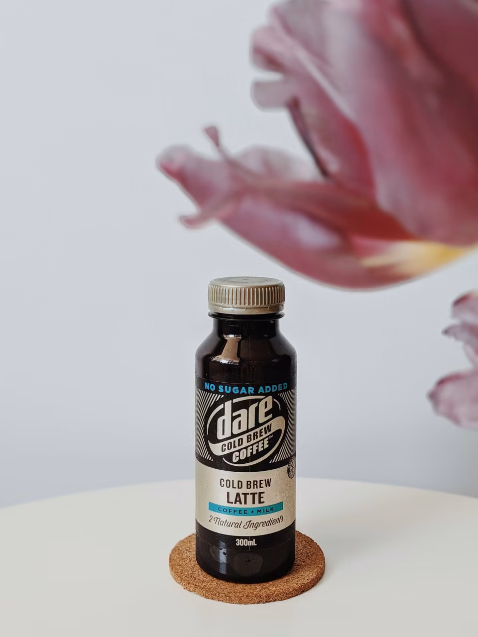 Bouteille de café froid près d’une fleur