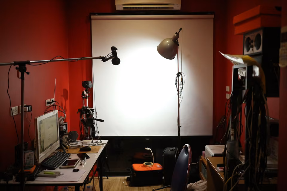 Espace de tournage vide avec microphone, éclairages et fond de studio.