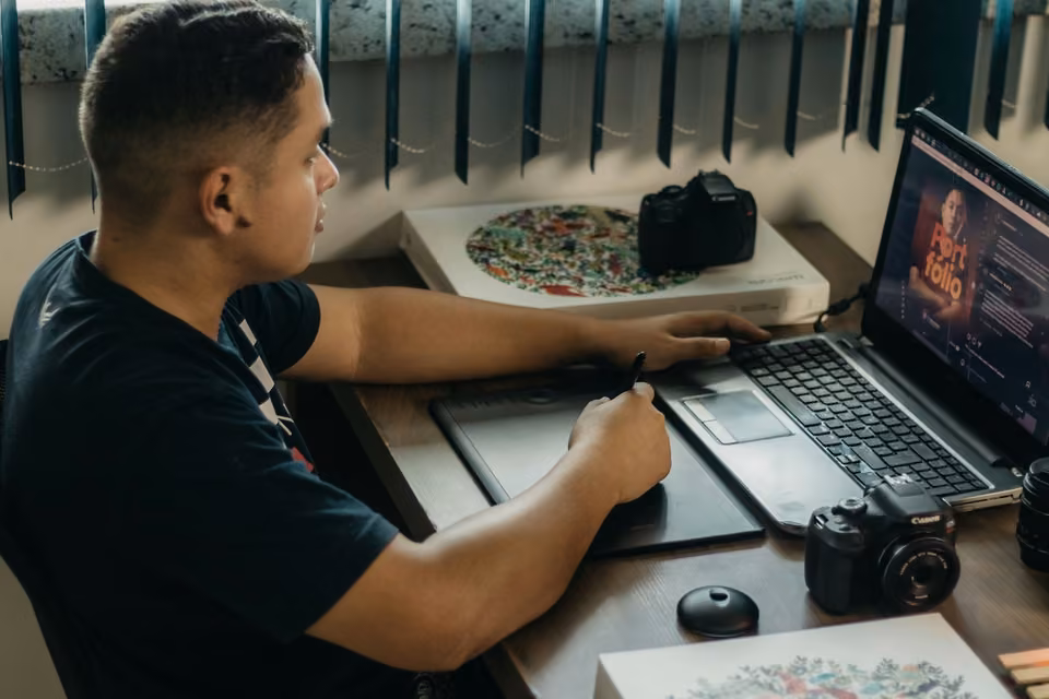 Photographe retouchant une image avec une tablette graphique et un portable.