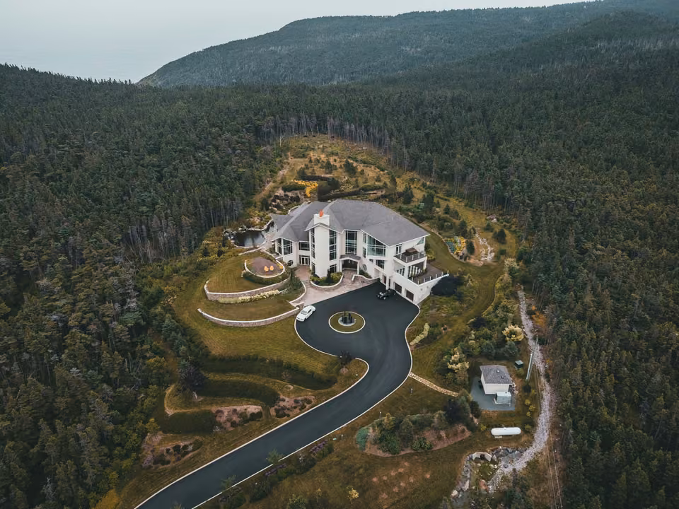 Vue aérienne d’une maison, de son jardin et de son accès.
