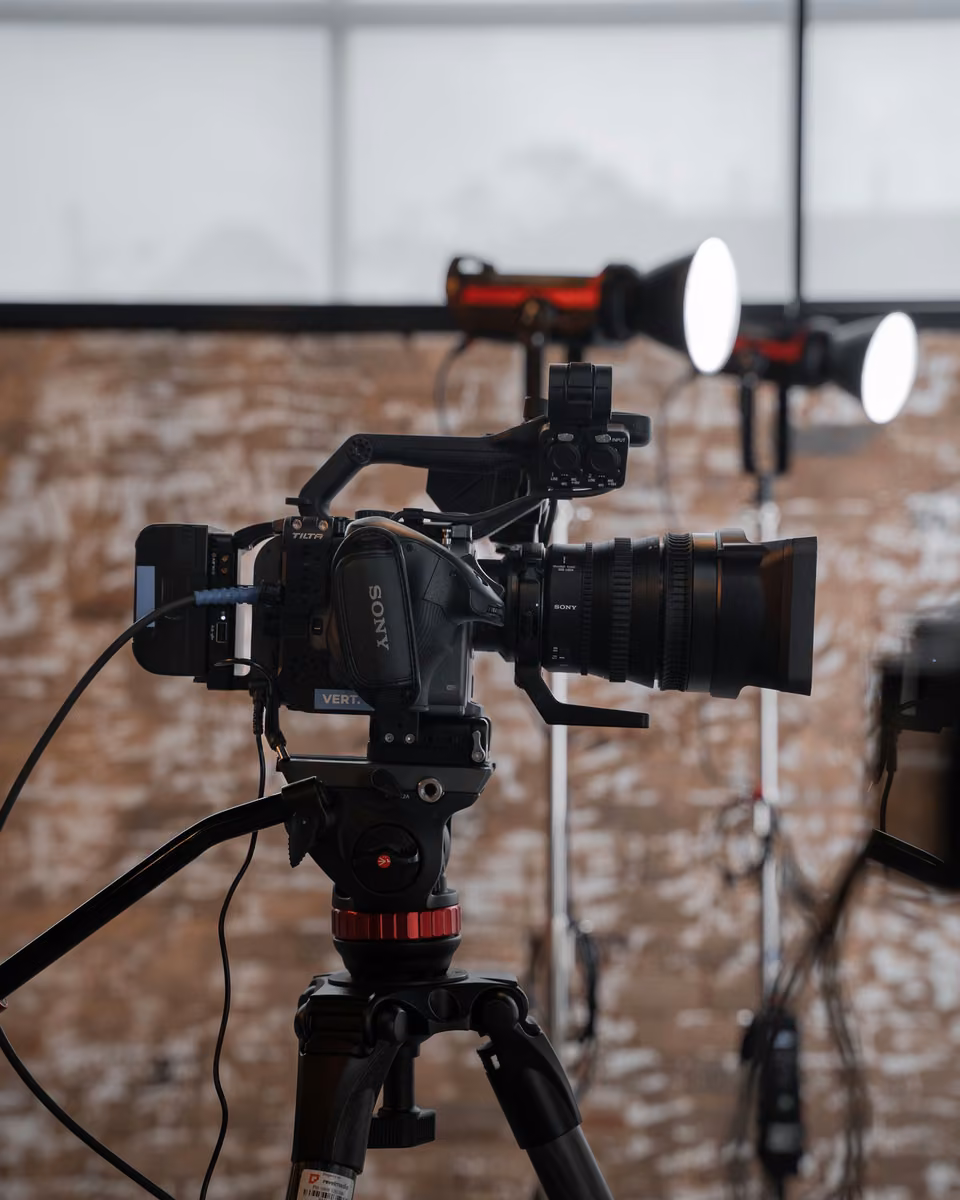 Caméra et éclairages dans un studio aux murs de brique