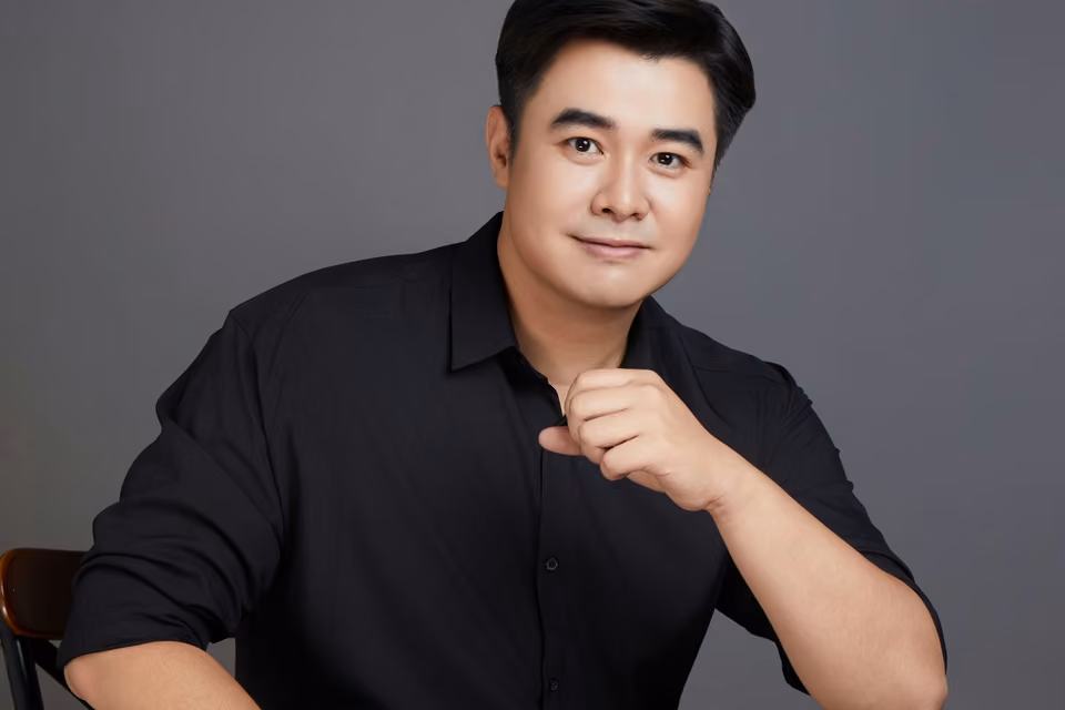 Portrait d’un homme sur un fond de studio neutre.
