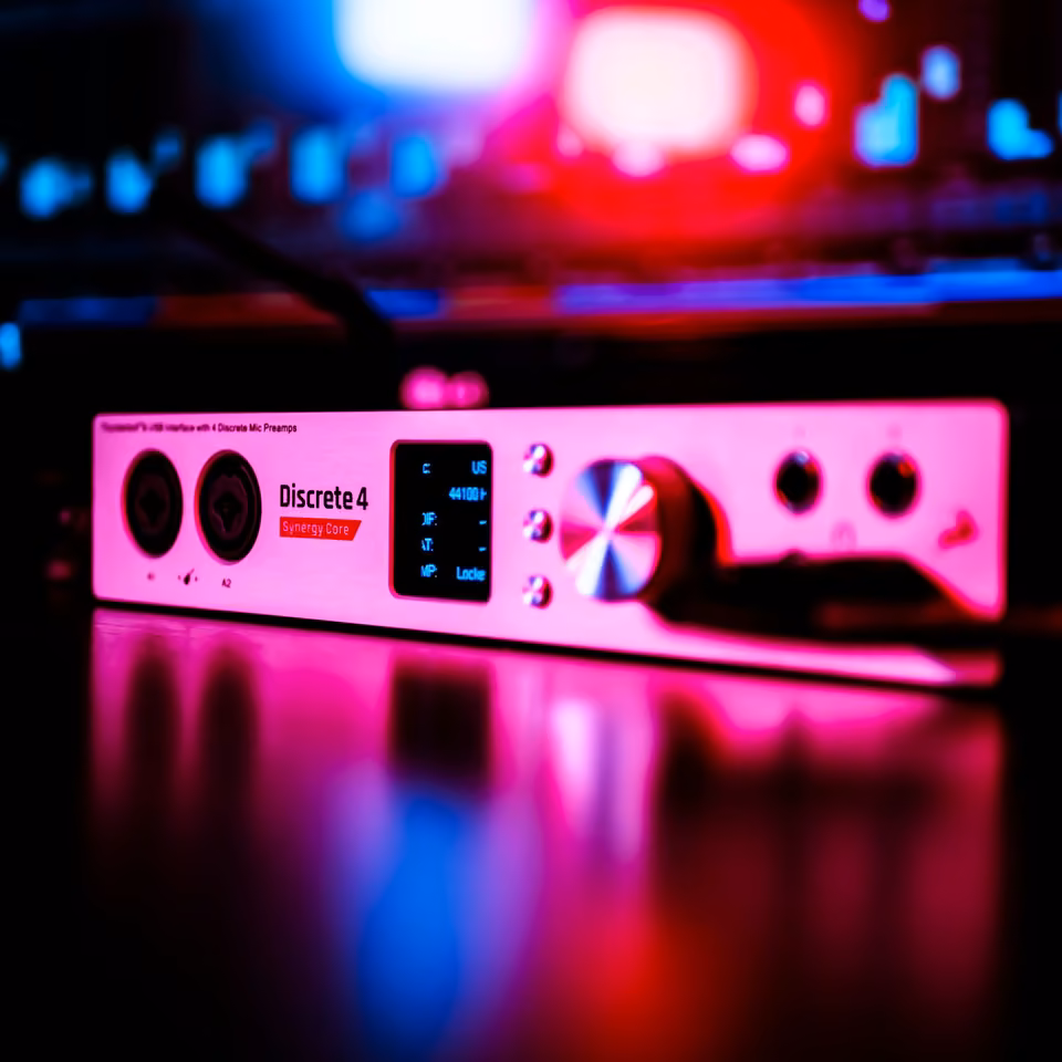 Interface audio en rack éclairée par des lumières de studio rouges et bleues.