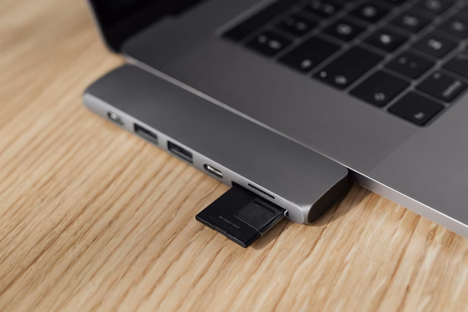 Carte SD insérée dans un adaptateur USB branché à un portable.
